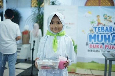 A young child holding a container of food AI-generated content may be incorrect.