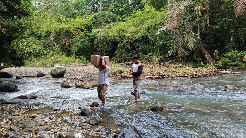 Two men standing in a river carrying boxes AI-generated content may be incorrect.